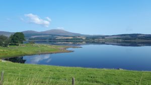 View over Clatteringshaws Loch on a bright sunny day.