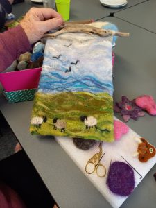 A felted scene of Blackface sheep on a hillside