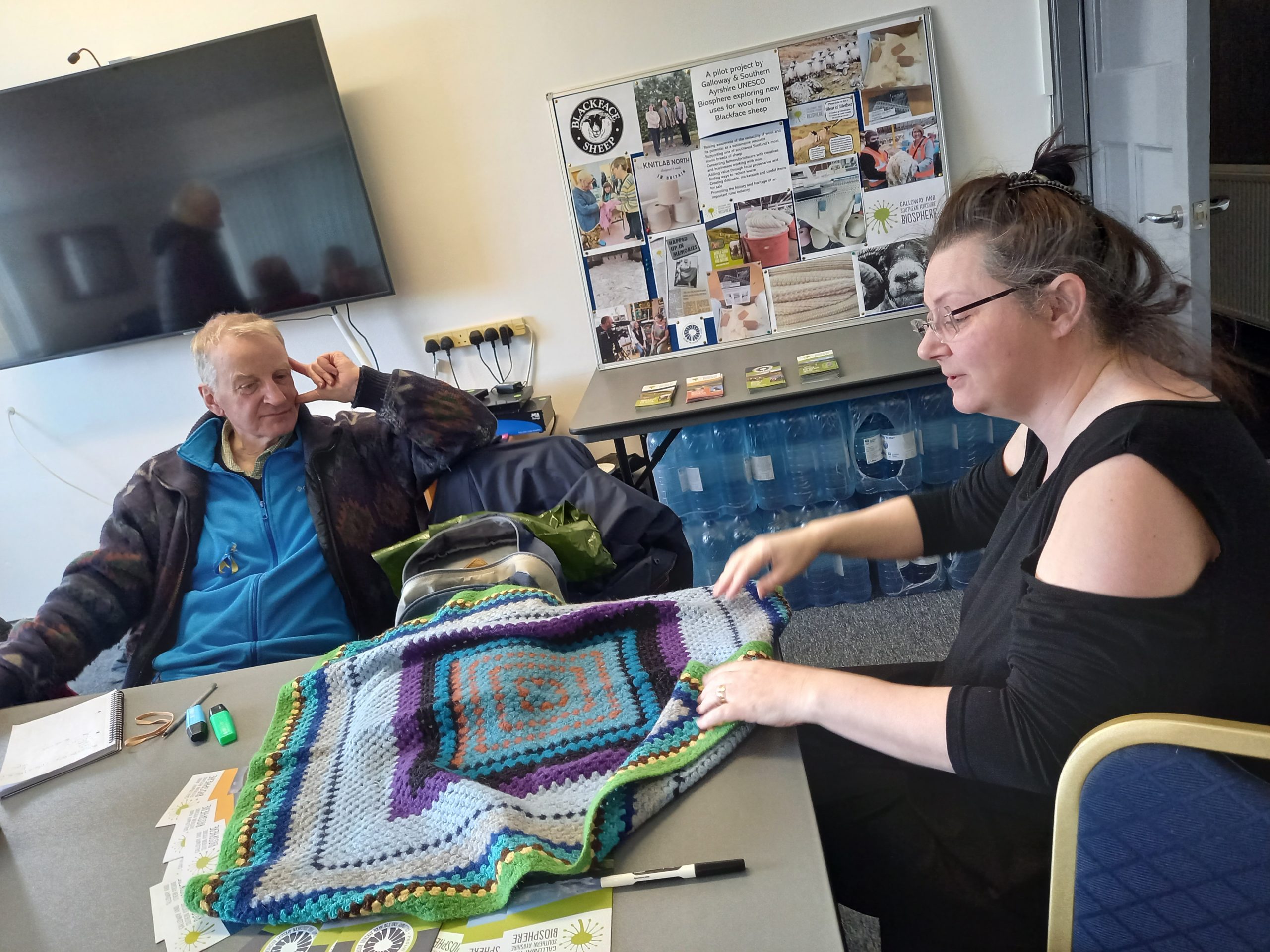 Members of The Wool gathering looking at a 50yr old crocheted pram blanket at the Barrhill Bleat n' Blether event.